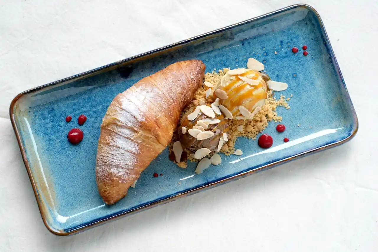 Warm buttered croissant served alongside hand-churned vanilla gelato