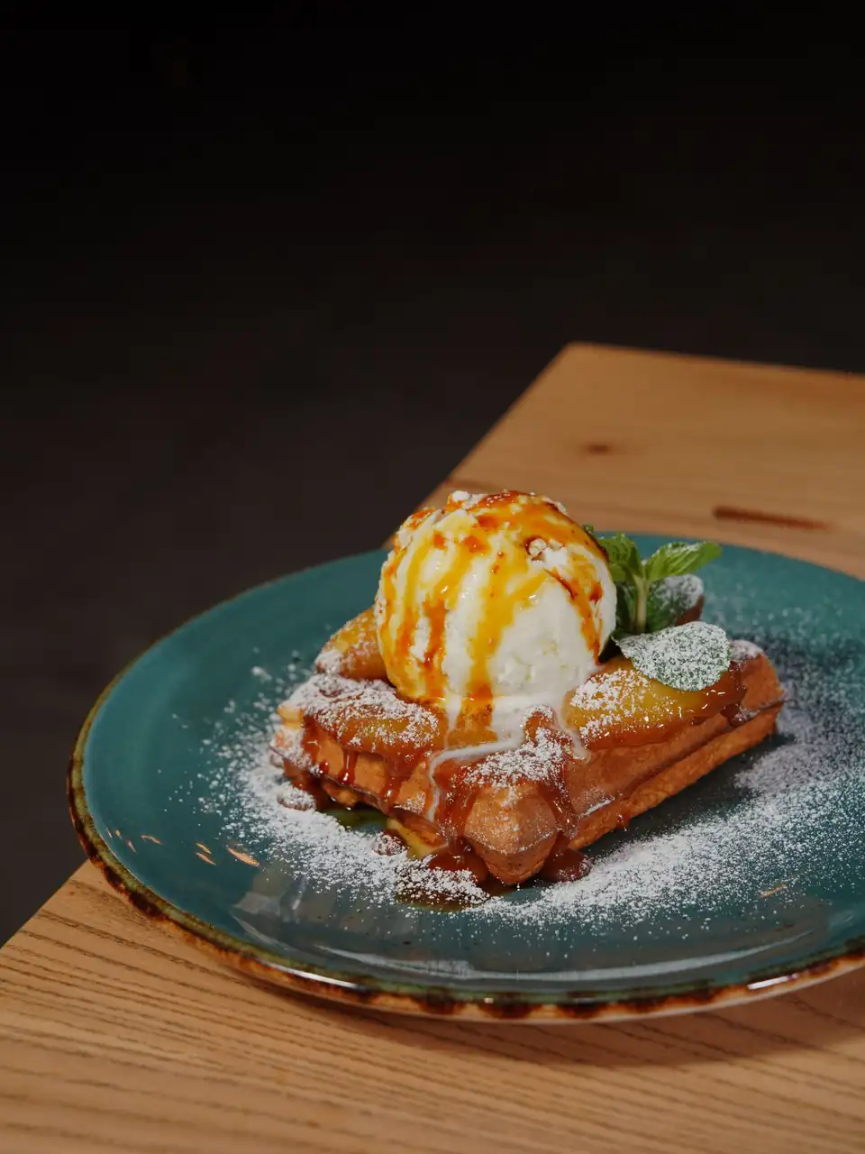 Crisp artisanal waffle topped with vanilla ice cream and caramel drizzle