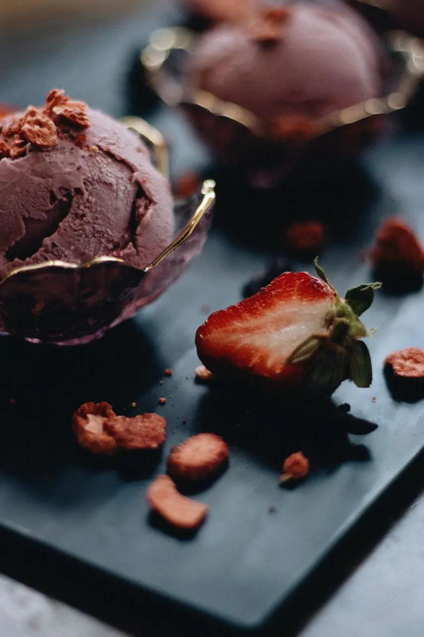 Fresh artisan strawberry ice cream presented with ripe berries on a table