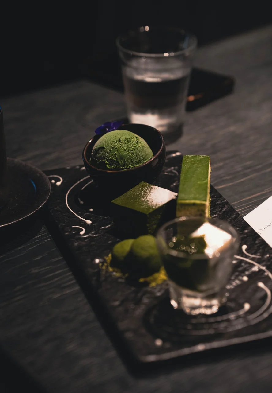 Artisan dessert pairing of chilled matcha and roasted nut cream served on minimalist pottery