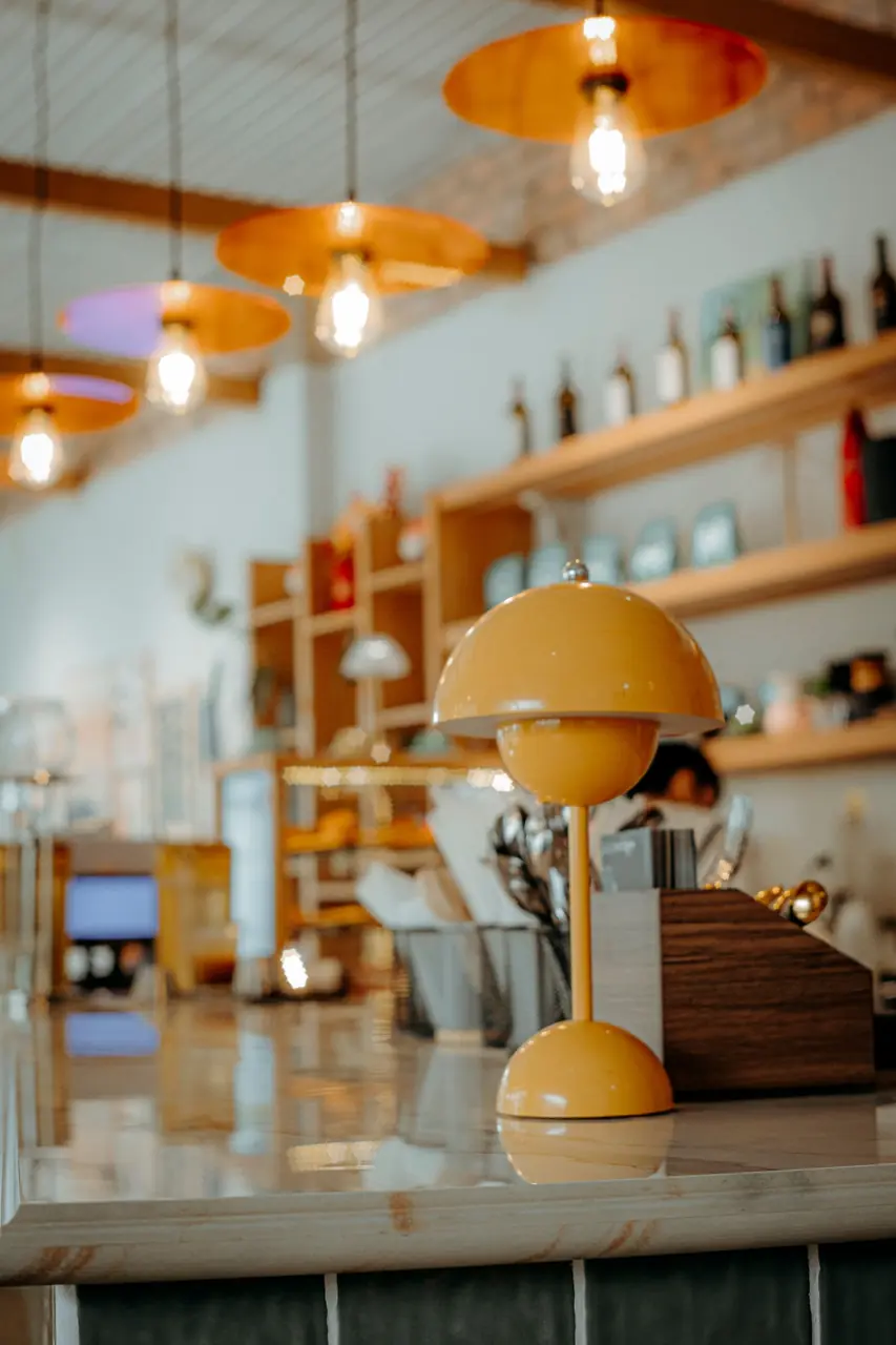 Bespoke dining setting with amber glow lamps, comfortable seating, and handcrafted timber tables