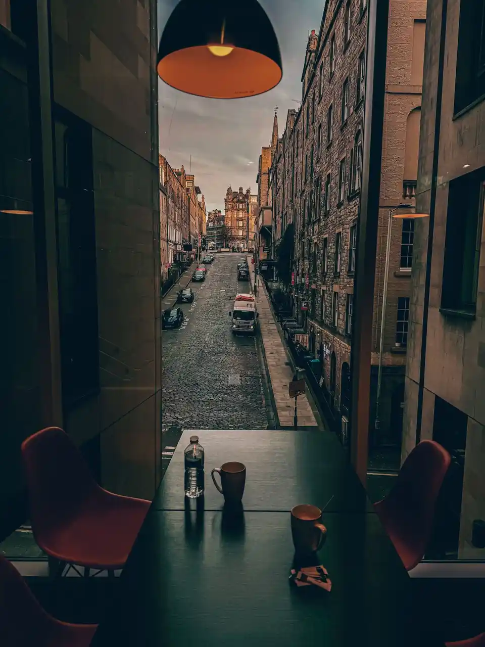 Atmospheric historic Edinburgh cobbled street seen through a welcoming café window
