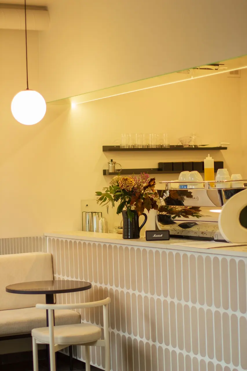 Intimate seating nook at Velmariq Essanova with warm table lamp and fluted wall finishes